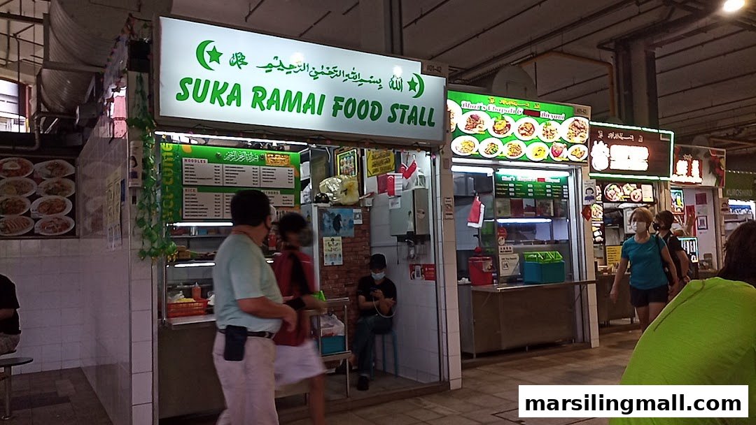 Exterior view of a bustling food stall with visible menus and customers.