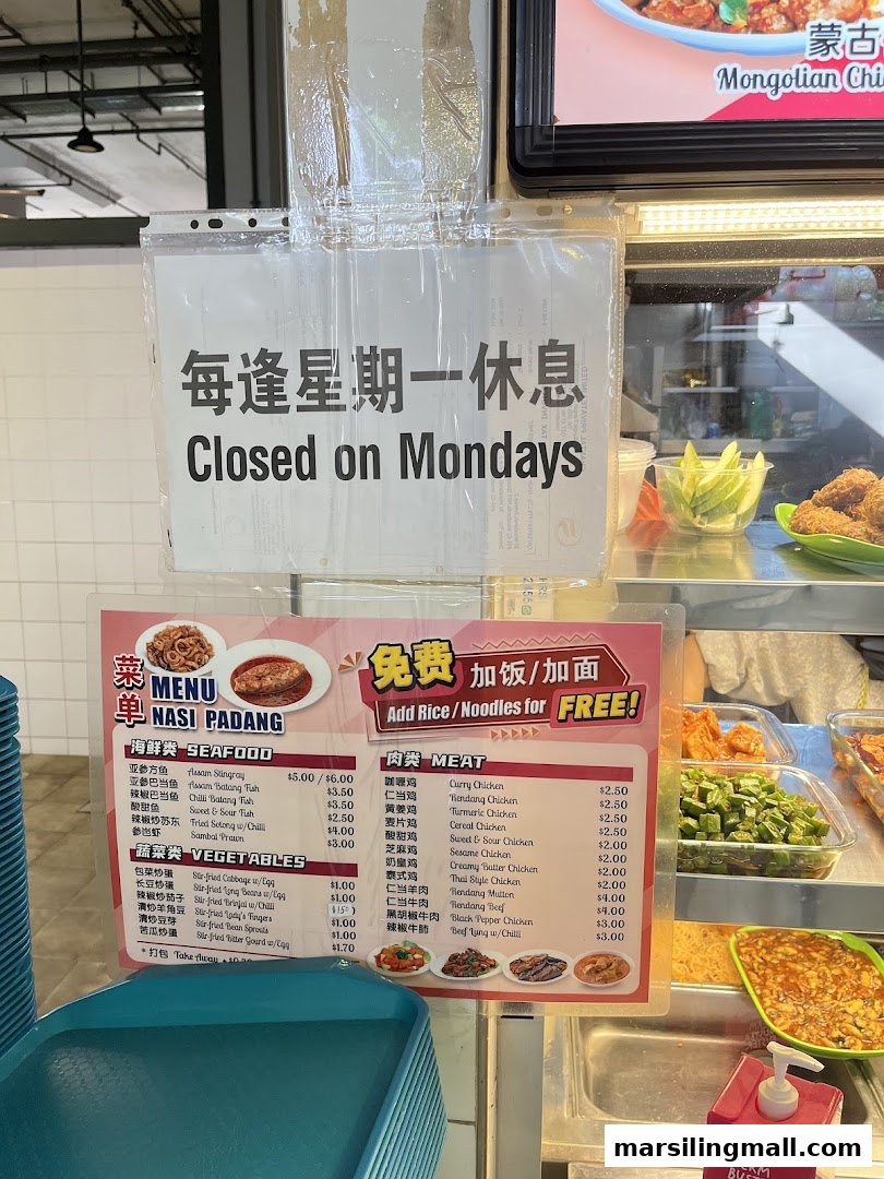 A menu board for Nasi Padang dishes, featuring seafood, meat, and vegetable options, with a 'Closed on Mondays' sign.