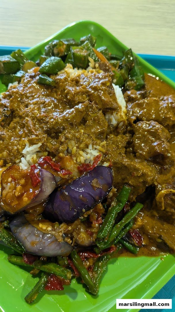 A vibrant plate of Indonesian Nasi Padang featuring rice, rich curry, eggplant, long beans, and okra.
