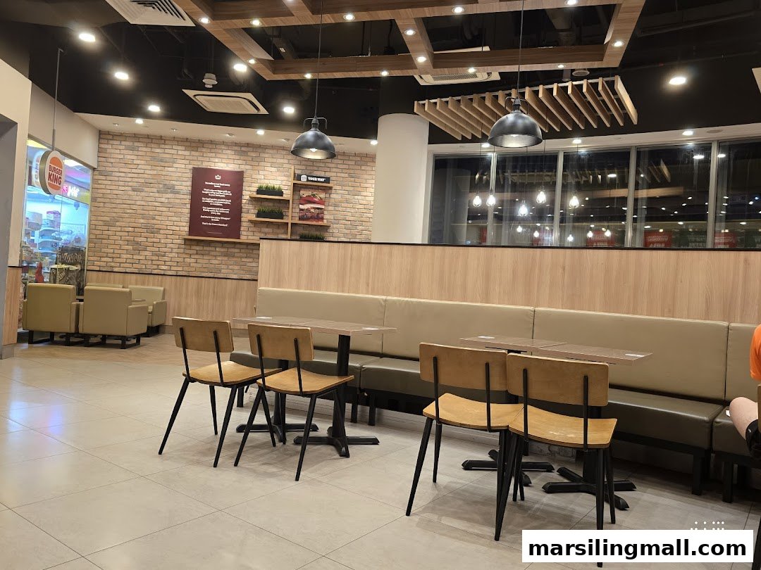 Modern interior of a Burger King restaurant featuring comfortable seating and brick wall accents.