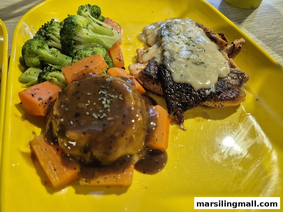 A delicious meal featuring a meat patty with gravy, grilled fish, and steamed vegetables on a yellow plate.