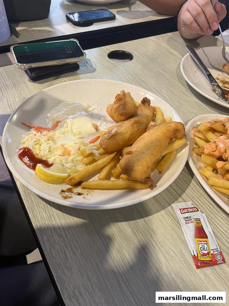 A plate of golden-fried fish and chips with coleslaw and lemon at Chef William.