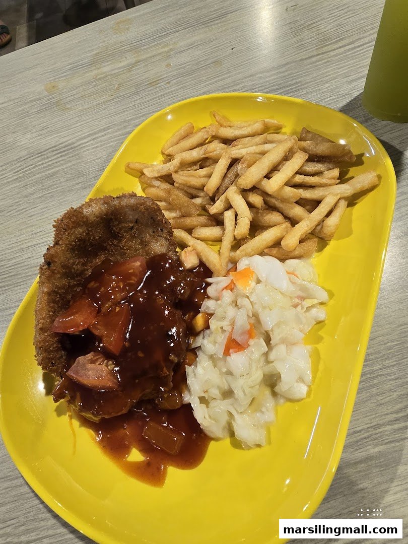 A vibrant yellow plate holds a breaded cutlet with sauce, golden fries, and fresh coleslaw.