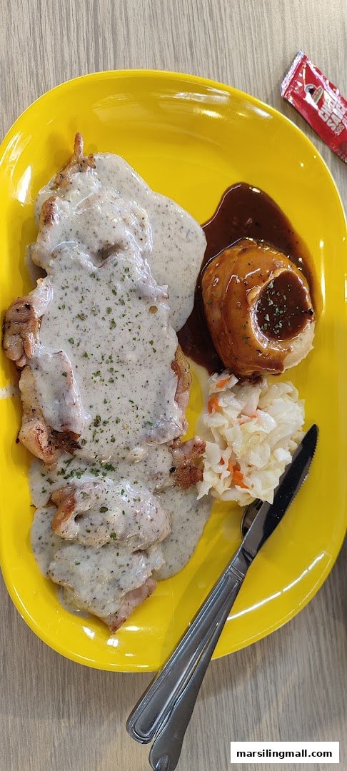 A delicious chicken dish with creamy mushroom sauce, mashed potato, and coleslaw on a vibrant yellow plate.