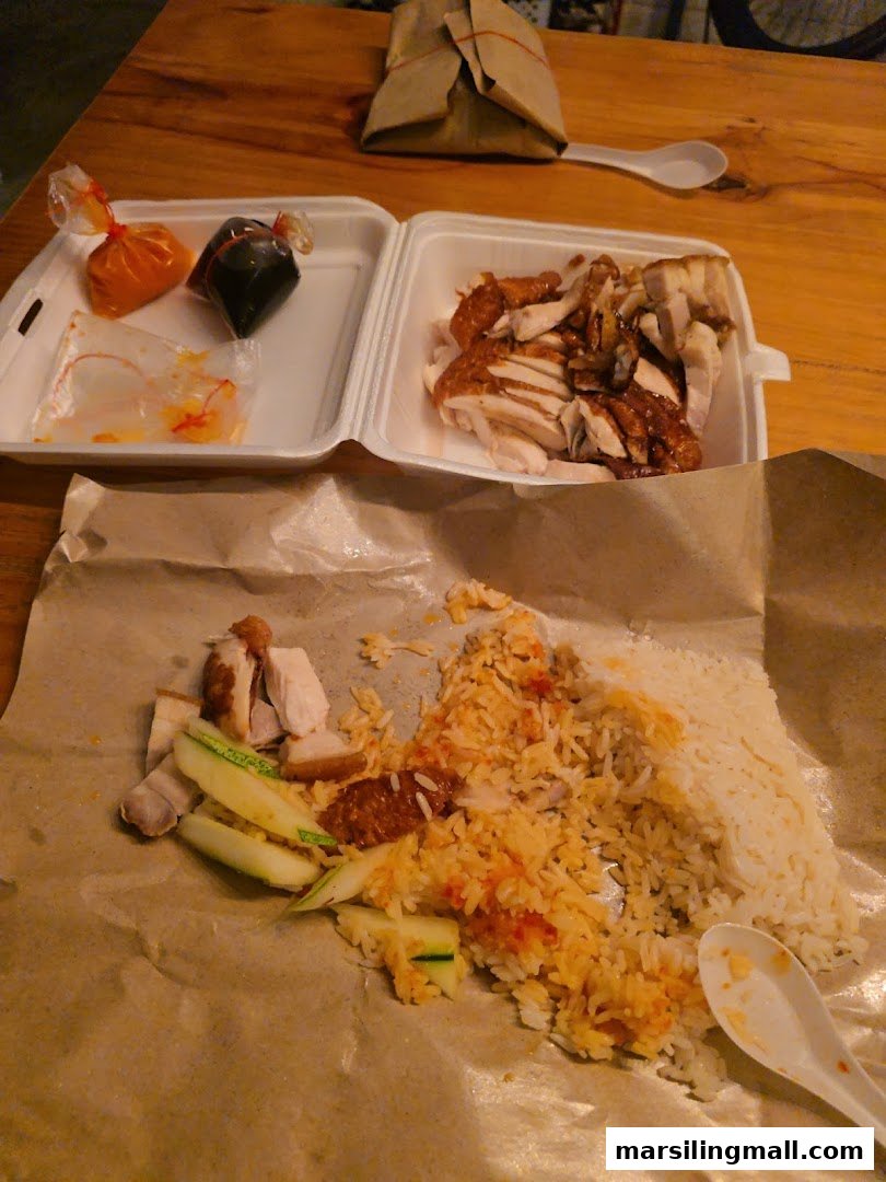 Delicious chicken rice and roasted meats served on a table, with takeaway packaging and sauces.
