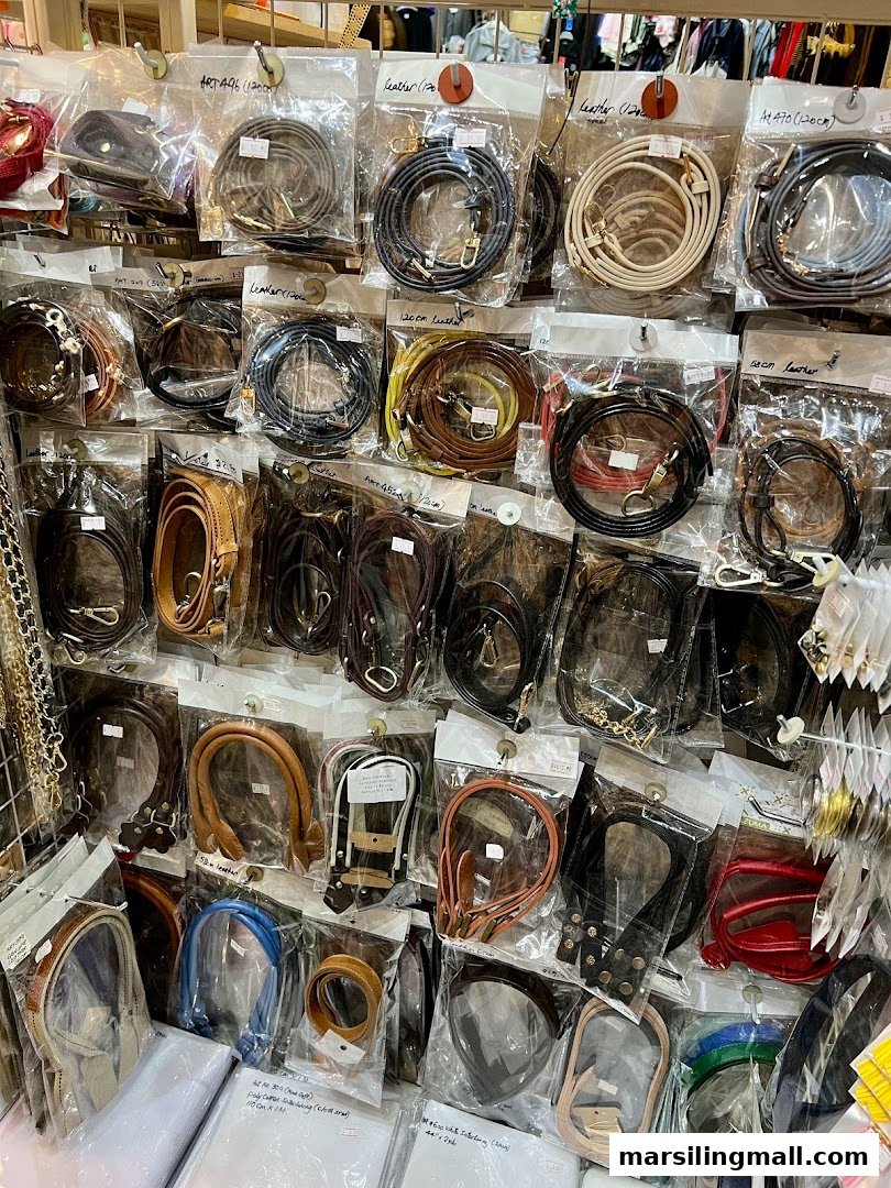 A wall display showcasing a wide variety of packaged bag straps and handles in different colors and materials.