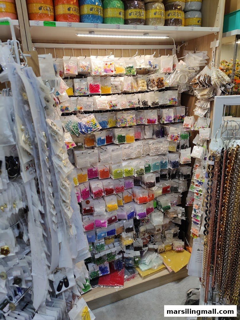 A vibrant display of colorful beads and crafting supplies neatly organized on shelves inside Crafting House.