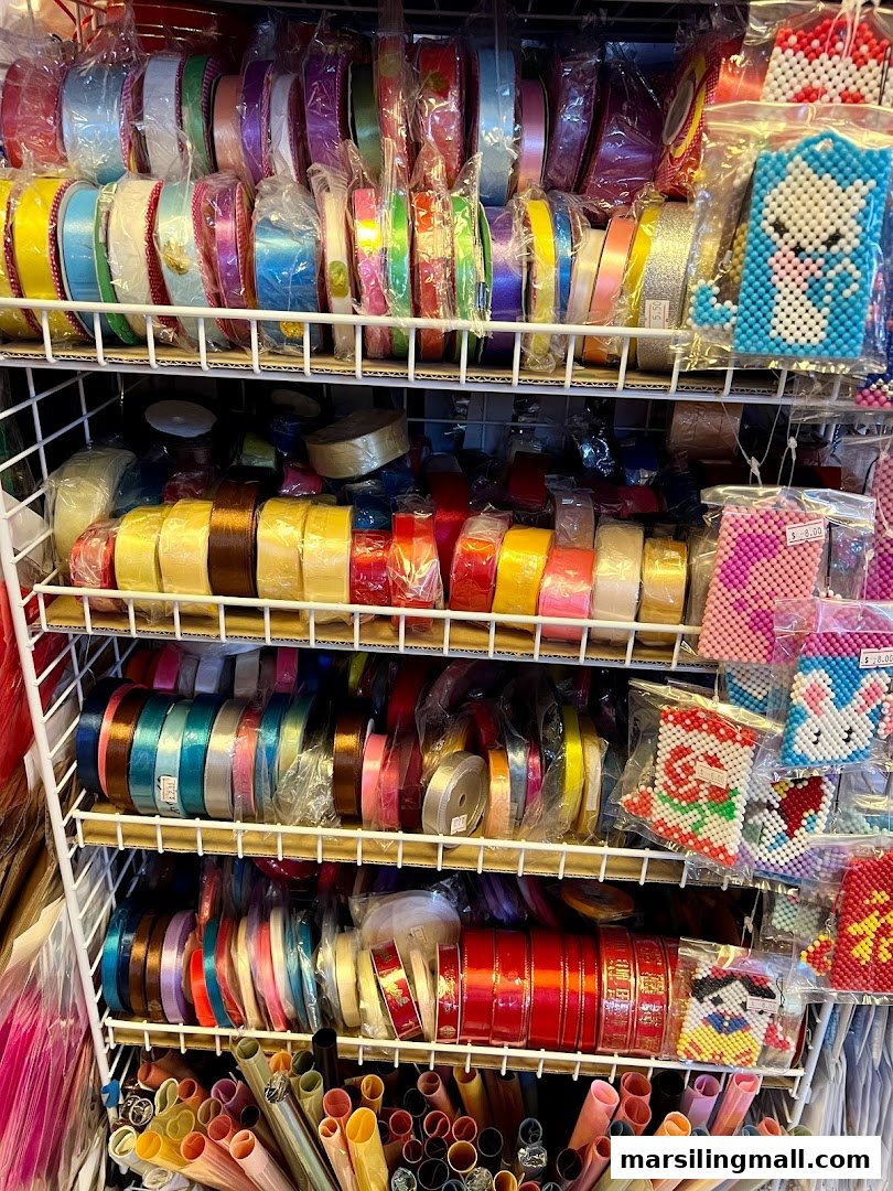 Shelves brimming with colorful ribbons, craft beads, and various art supplies at Crafting House.