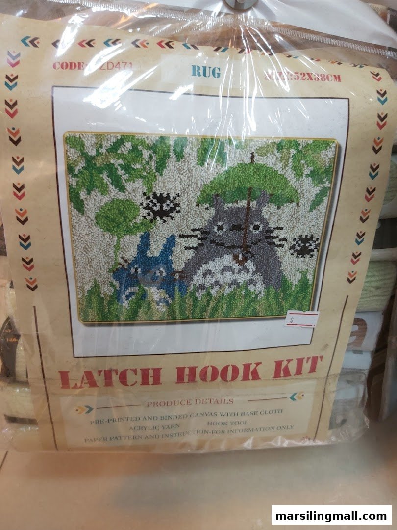 A packaged latch hook rug kit featuring a Totoro-like character design, ready for crafting.
