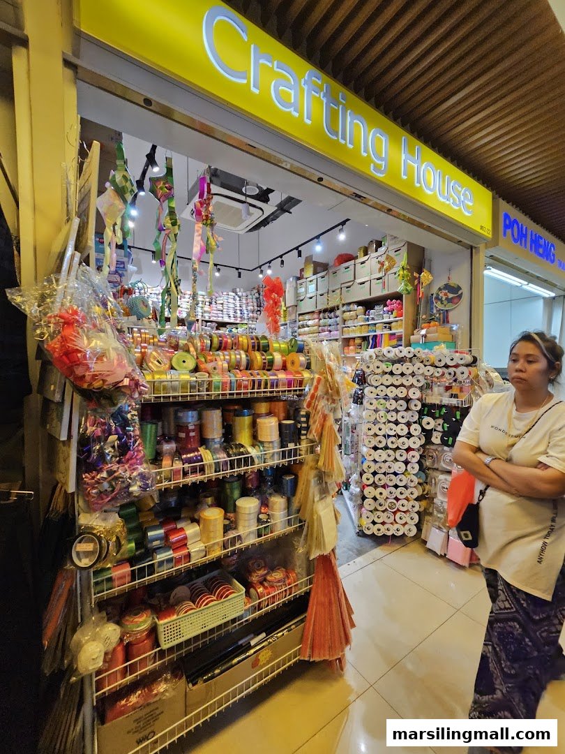 The shop front of Crafting House, a vibrant craft supply store, filled with colorful ribbons and materials.