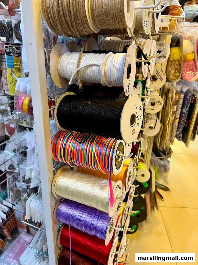 A retail display rack filled with various spools of colorful cords and threads.