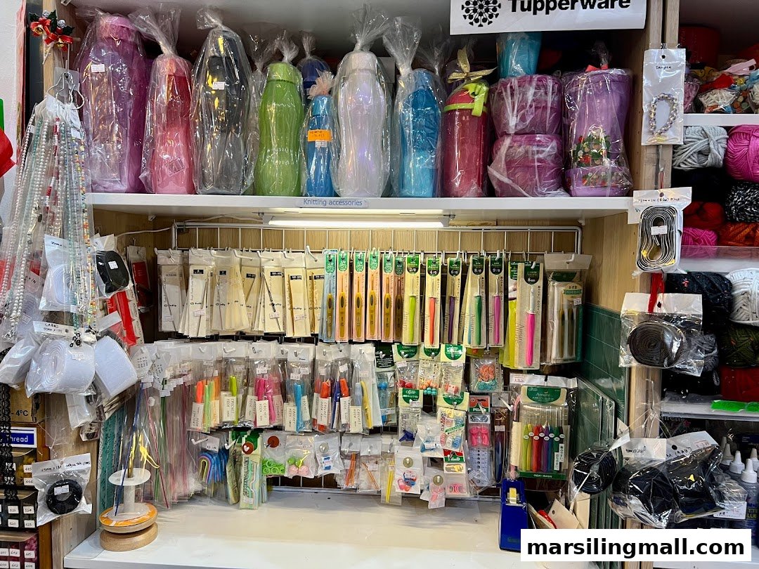Shelves stocked with knitting accessories, yarn, and Tupperware products in a craft shop.