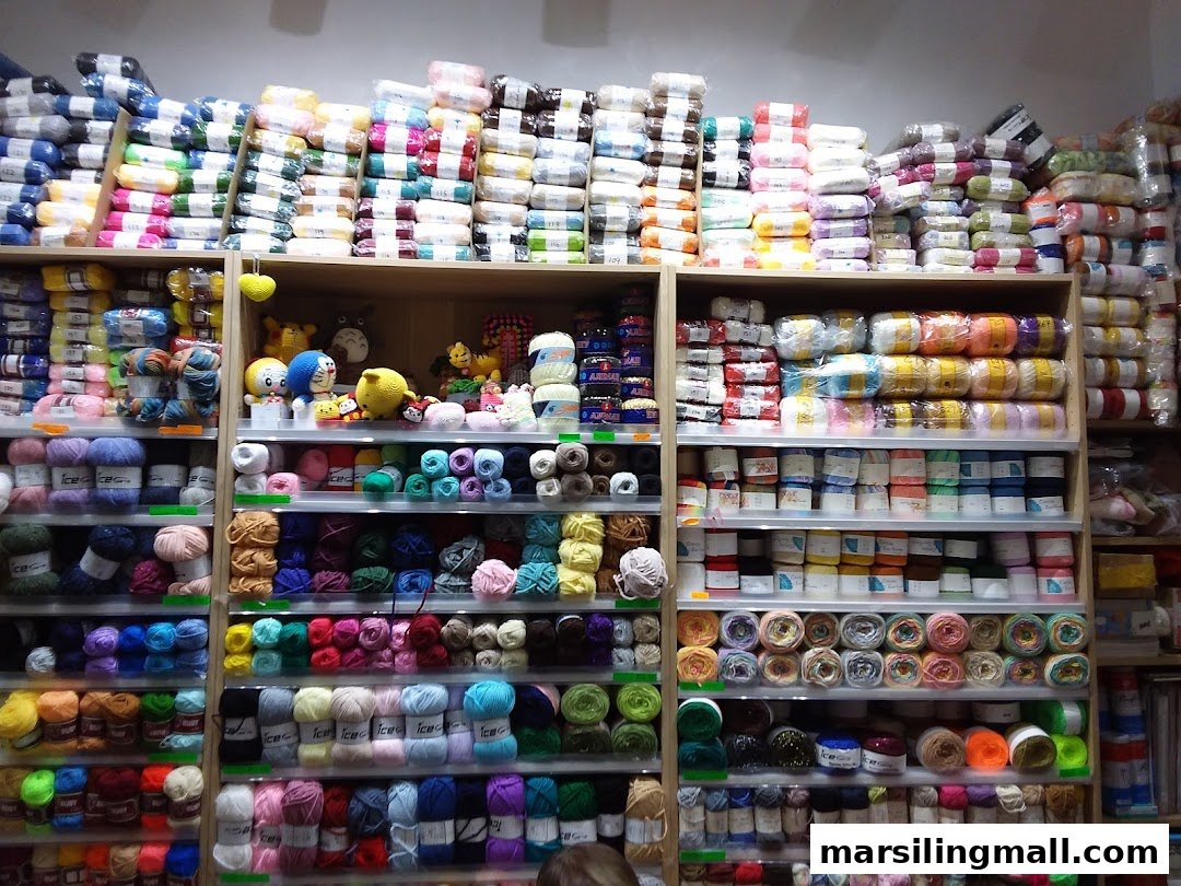 Shelves brimming with a vibrant assortment of yarn and craft supplies in a retail store.