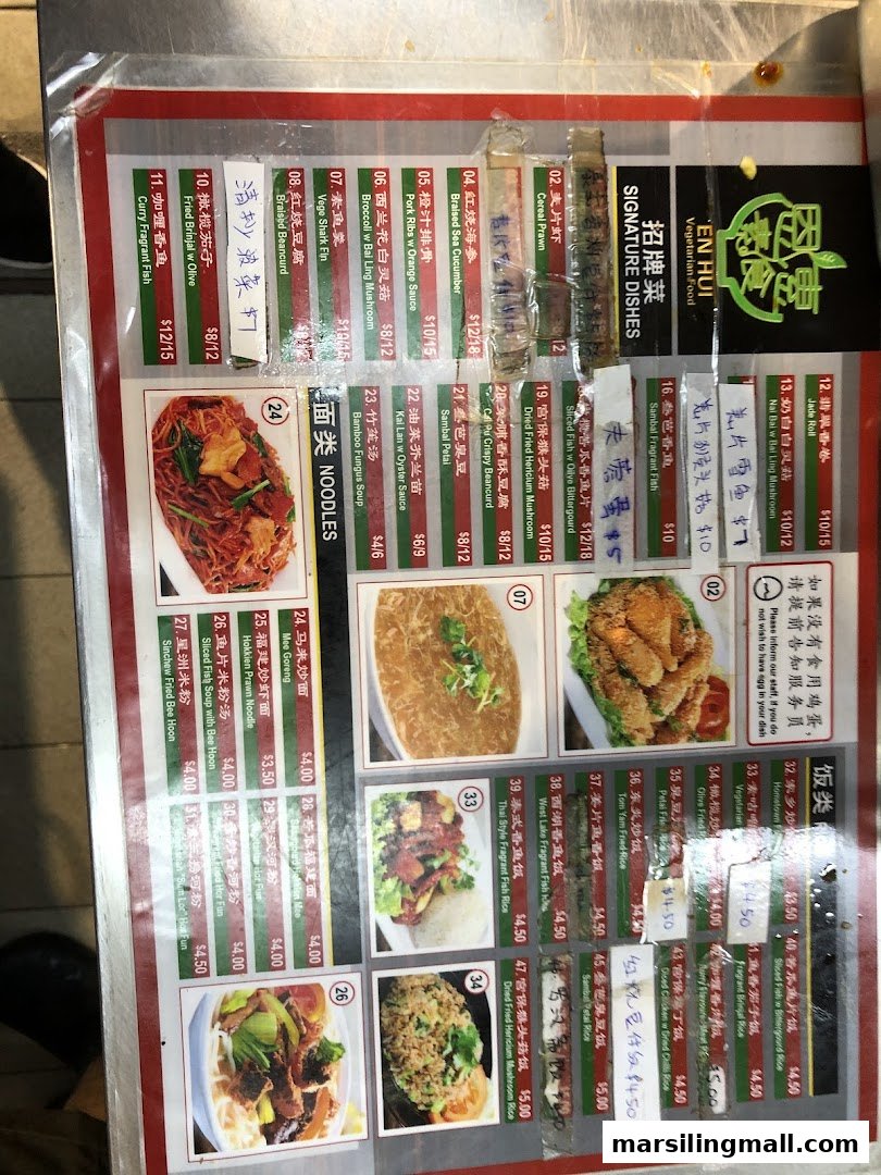 A detailed menu board from En Hui Vegetarian, showcasing a variety of signature dishes, noodles, and rice options.