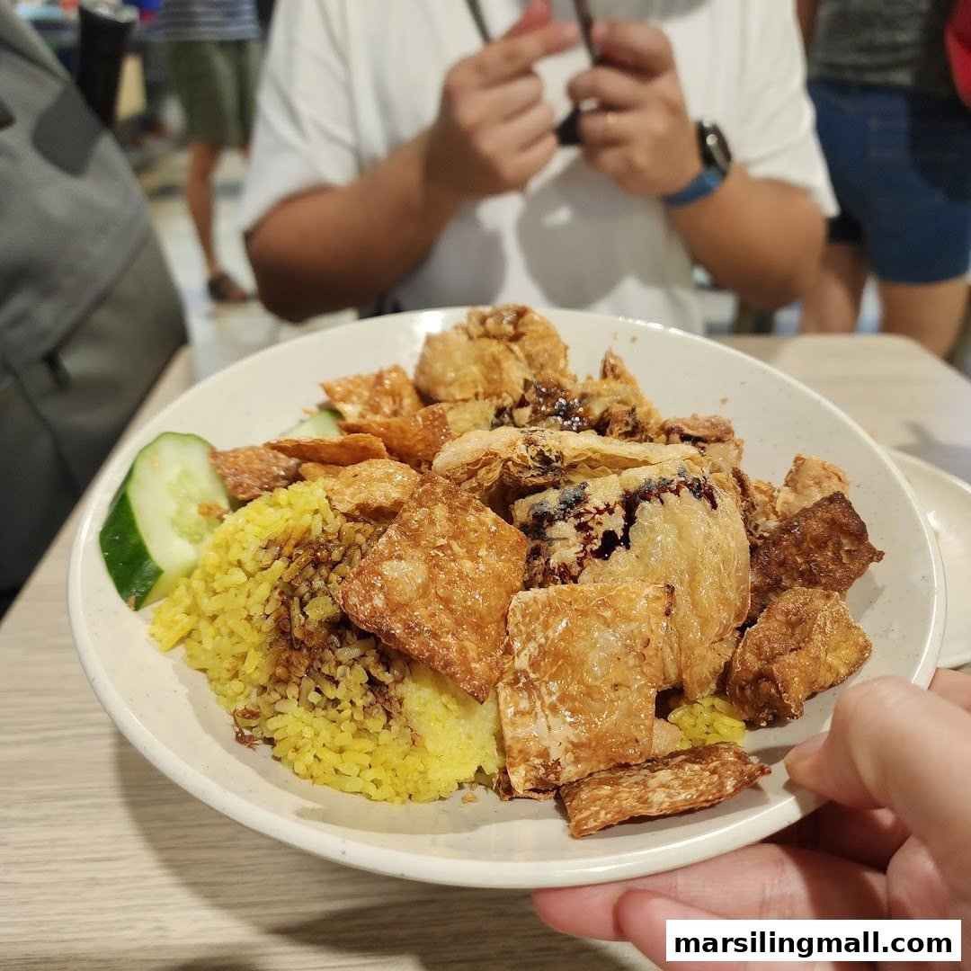 A close-up of a vibrant vegetarian dish featuring yellow rice, fried tofu skin, and cucumber.
