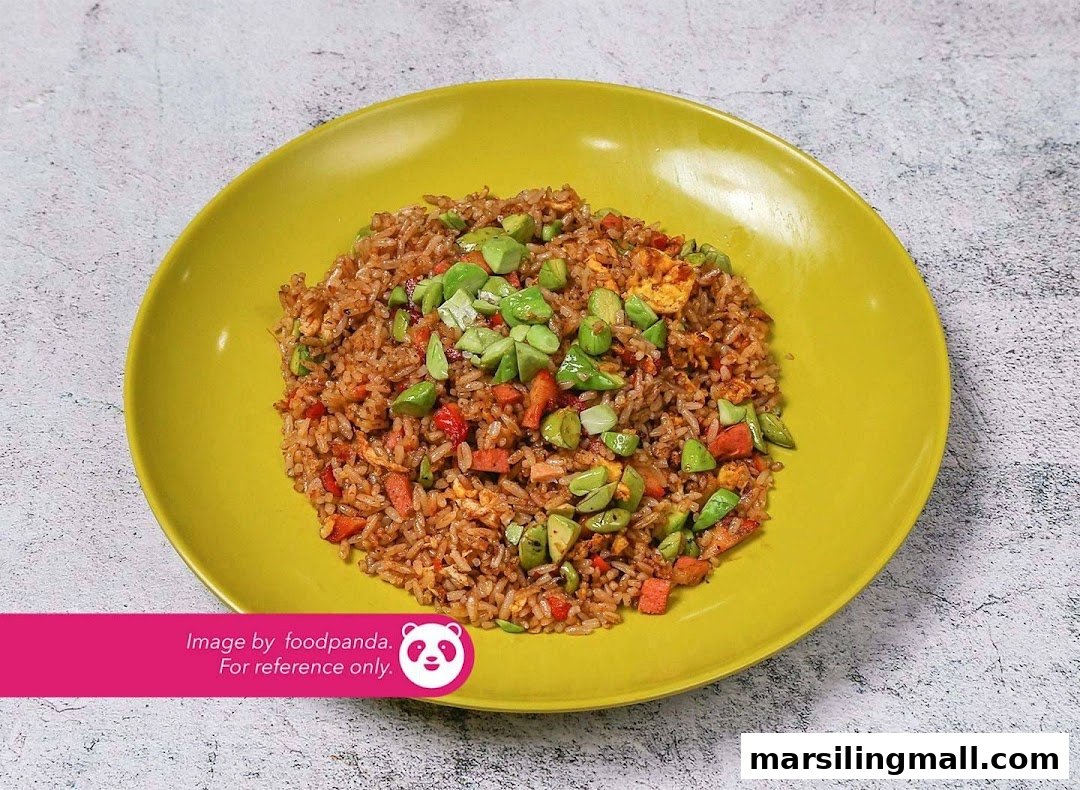 A vibrant plate of vegetarian fried rice topped with petai beans and mixed vegetables.