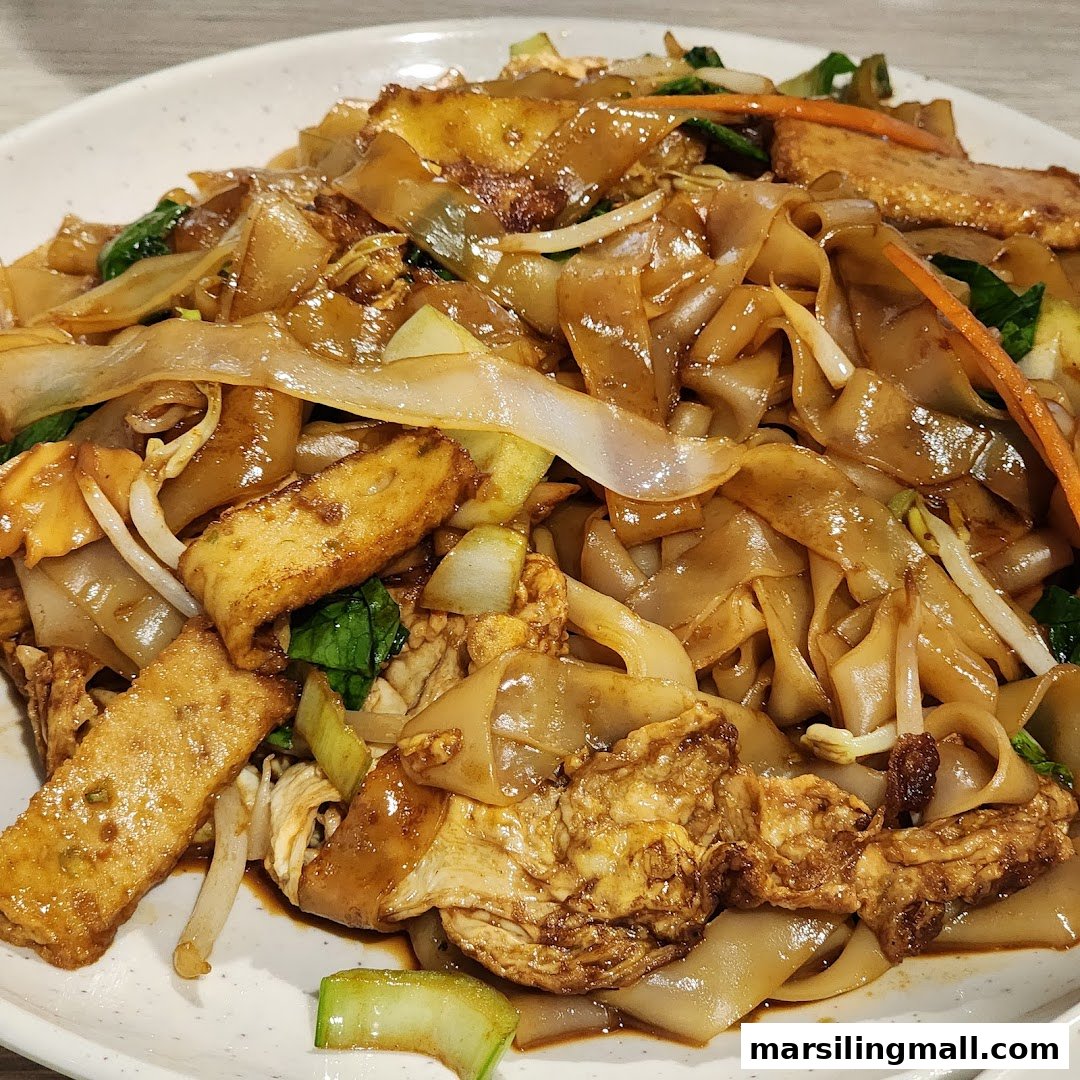 A close-up of delicious stir-fried flat noodles with vegetables and mock meat from En Hui Vegetarian.