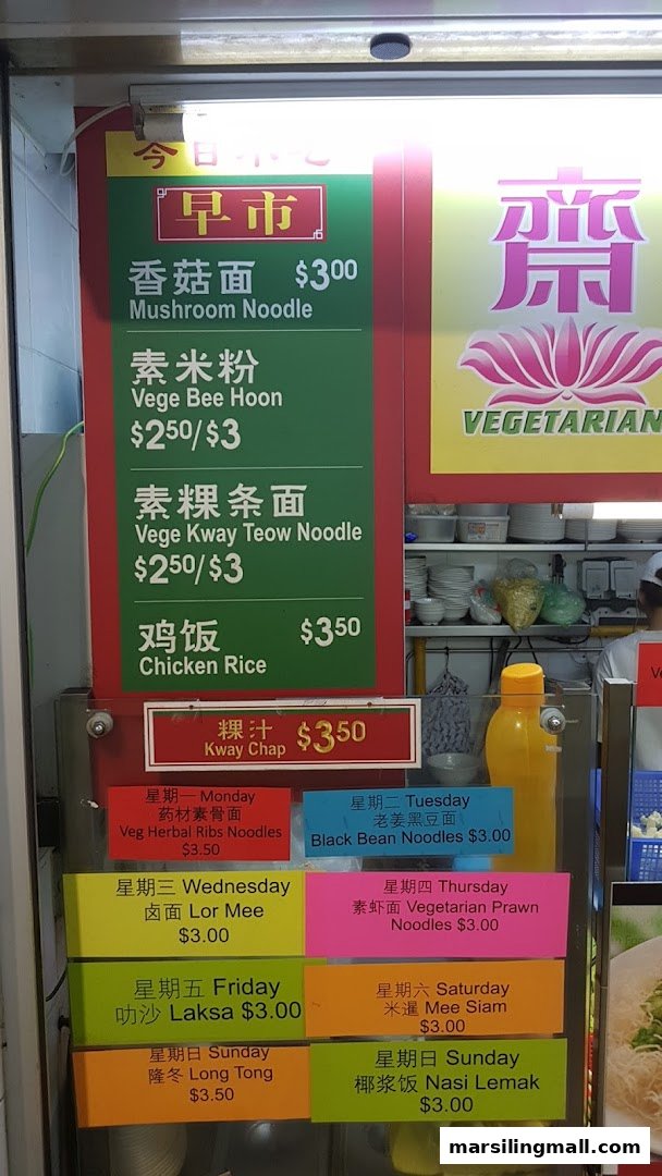 A vibrant menu board displaying vegetarian noodle dishes, rice, and daily specials with prices.