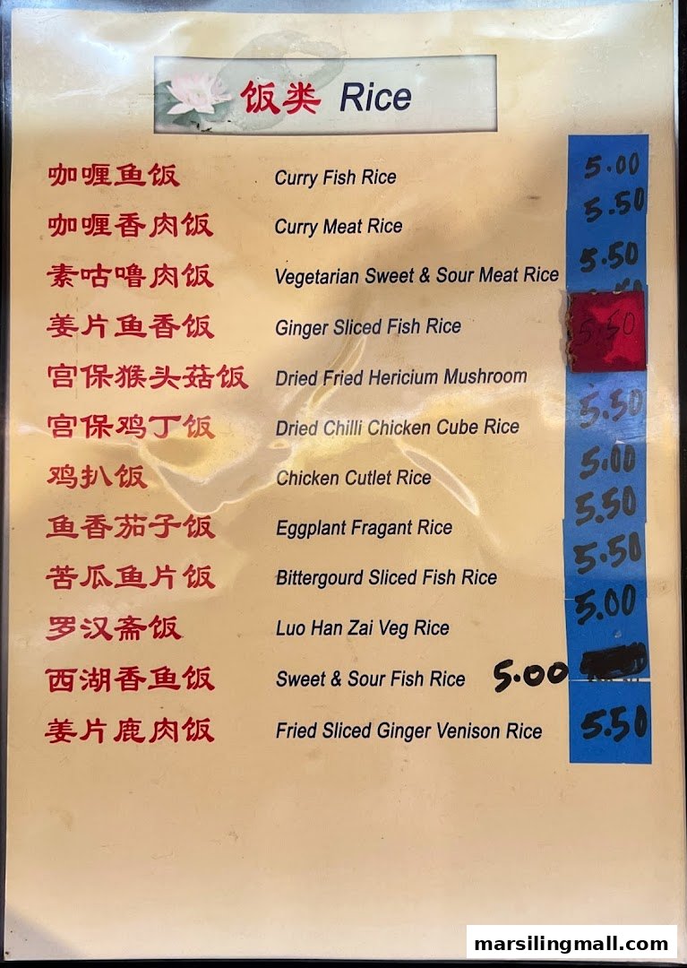 A detailed menu board displaying various rice dishes with their prices in a vegetarian restaurant.