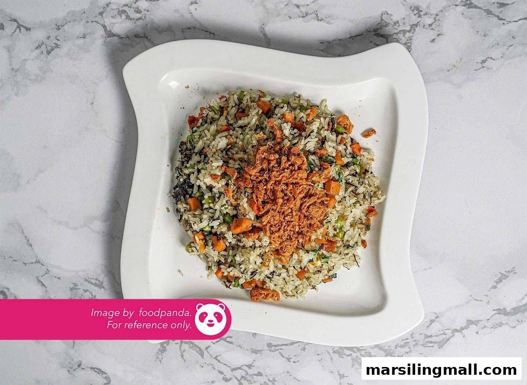 A plate of vegetarian fried rice topped with crispy golden flakes on a white wavy dish.