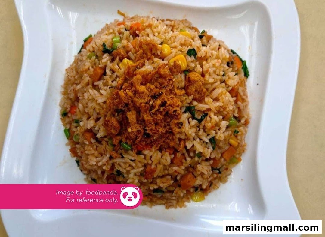 A close-up of vegetarian fried rice topped with crispy savory bits on a white plate.