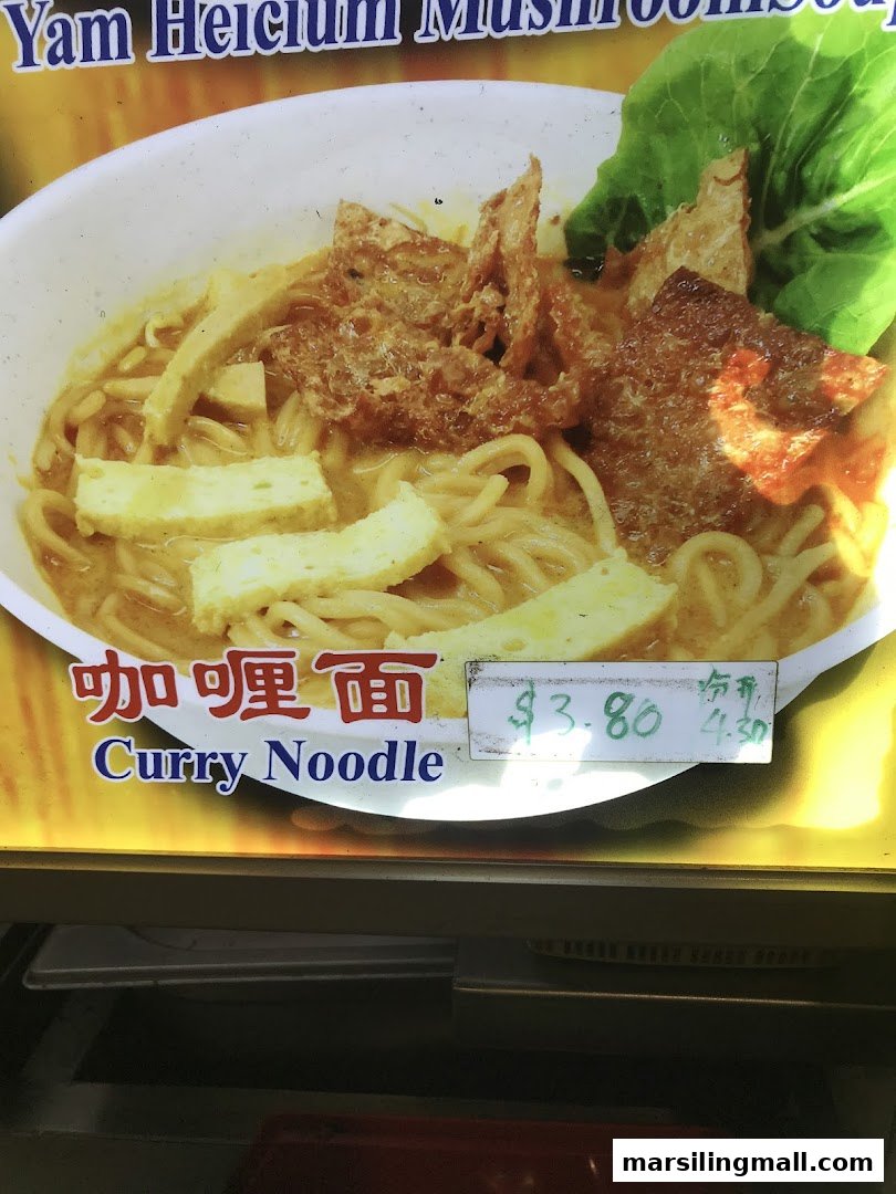 A vibrant close-up of a vegetarian curry noodle dish with mock meat and tofu puffs.