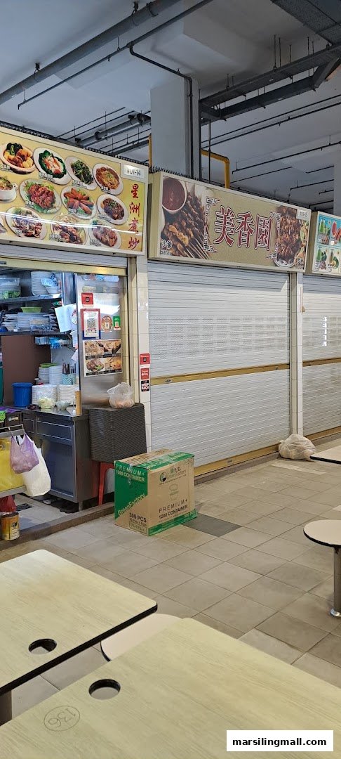 A hawker center scene featuring multiple food stalls, one of which is preparing for service.