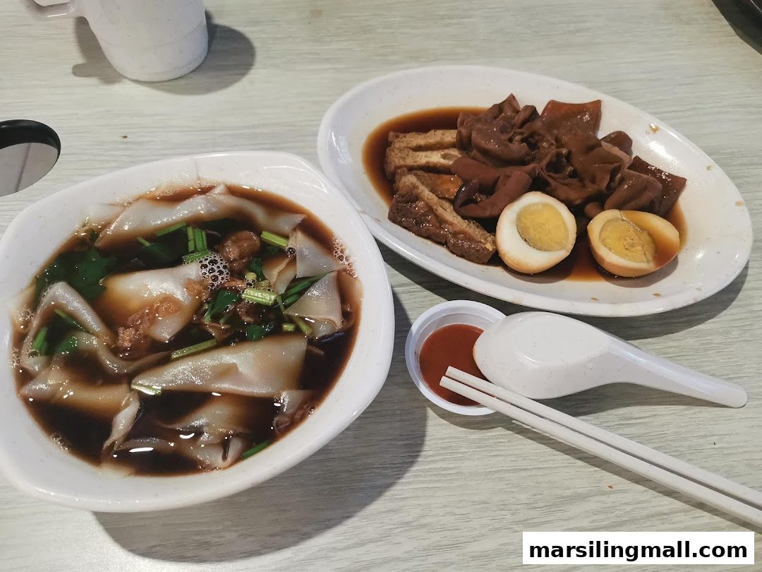 A bowl of kway chap with a side plate of braised pig's organs, eggs, and tofu.