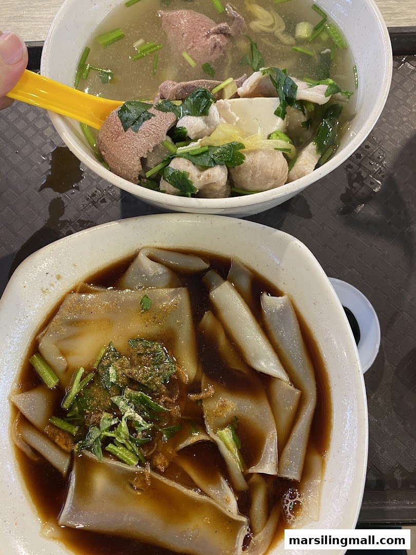 Two bowls of traditional Chinese dishes: pig organ soup and kway chap, served on a tray.
