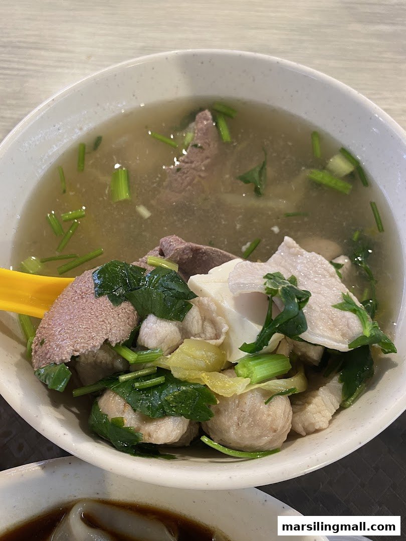 A hearty bowl of pig's organ soup with various ingredients and clear broth.