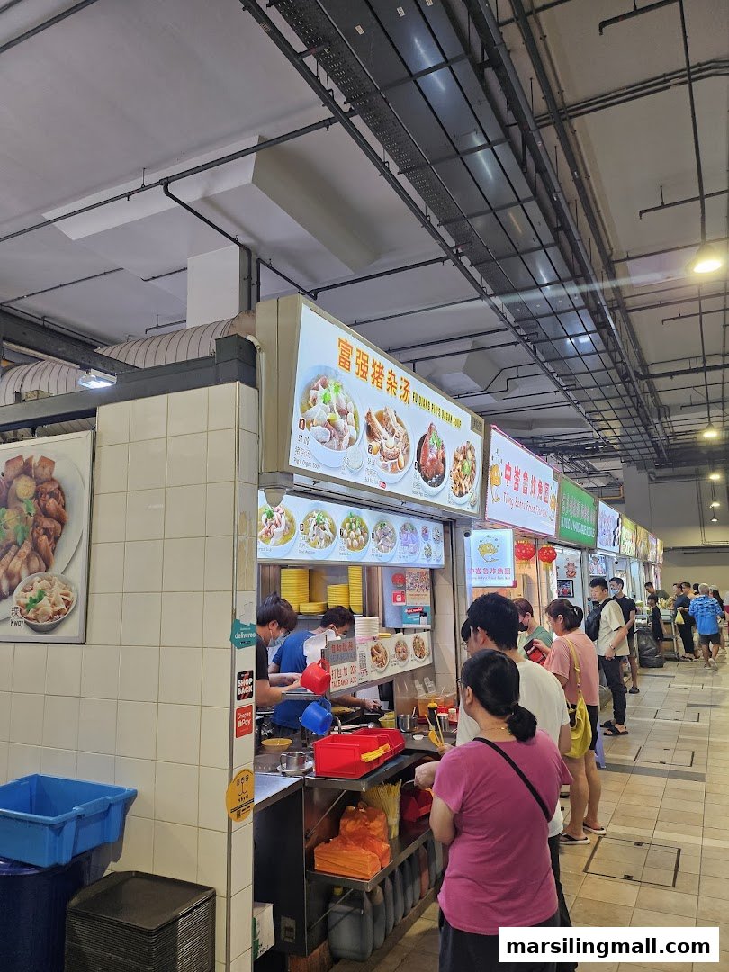 A bustling food stall, 'Fu Qiang Pigs Organ Soup', with customers queuing for traditional dishes.