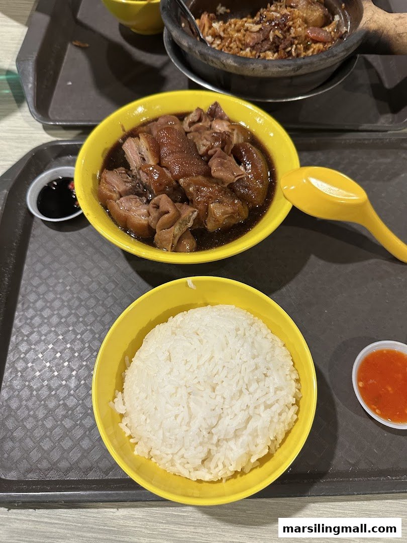 A hearty meal featuring braised pig's organs/trotters with dark sauce, served with white rice and chili.