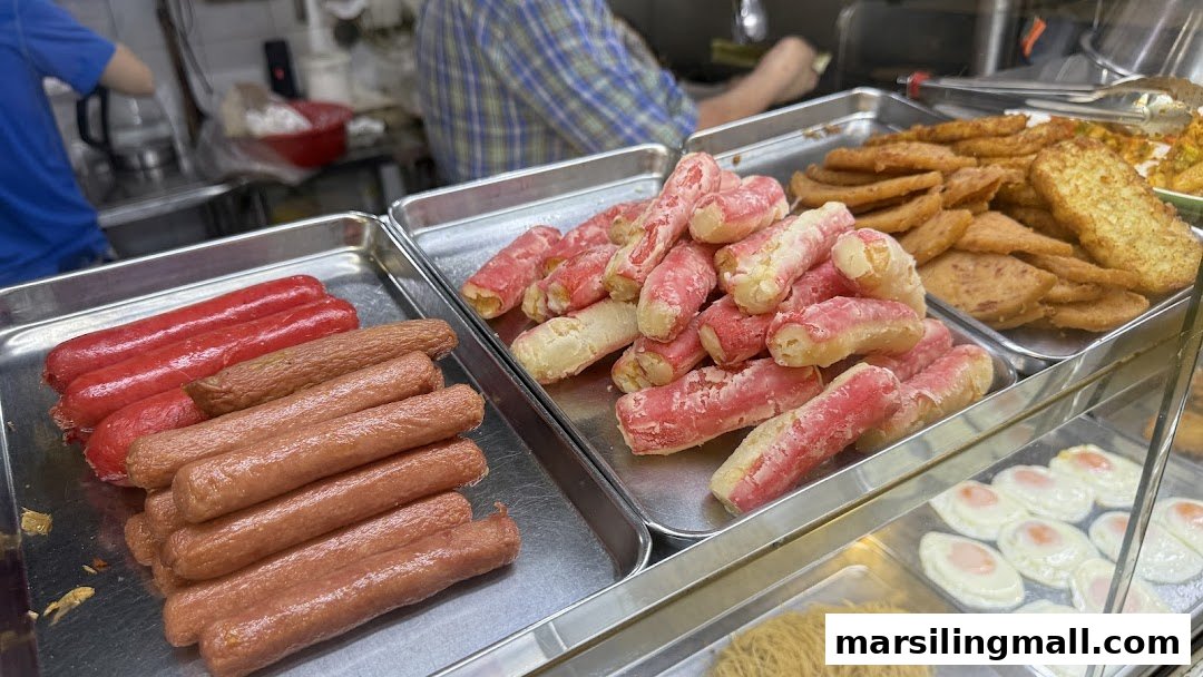 A display of various fried food items including sausages, fried patties, and eggs, ready for serving.