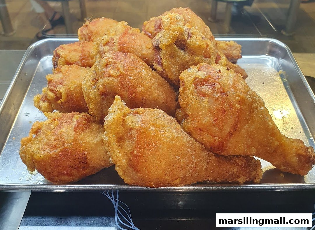 A close-up of a tray filled with crispy, golden-brown fried chicken pieces.