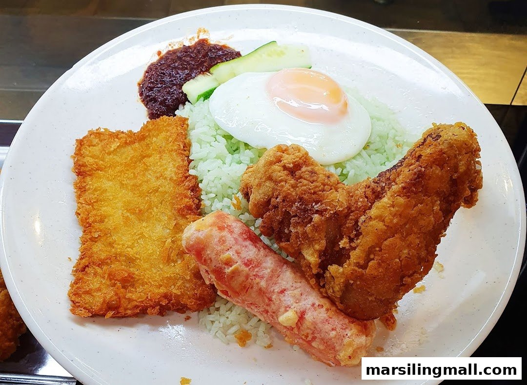 A vibrant plate of Nasi Lemak featuring green rice, fried chicken, fish cake, sausage, egg, sambal, and cucumber.