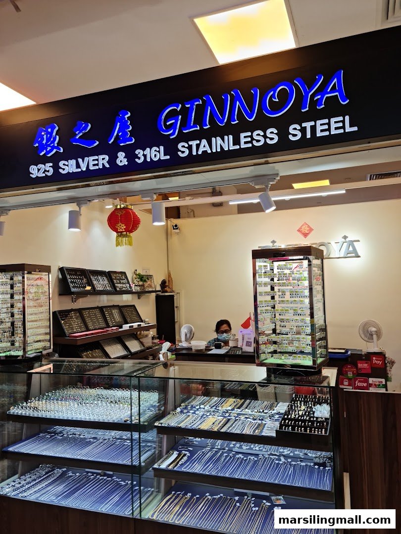 Interior view of Ginnoya 925 Silver shop, showcasing display cases filled with jewelry and a staff member at the counter.
