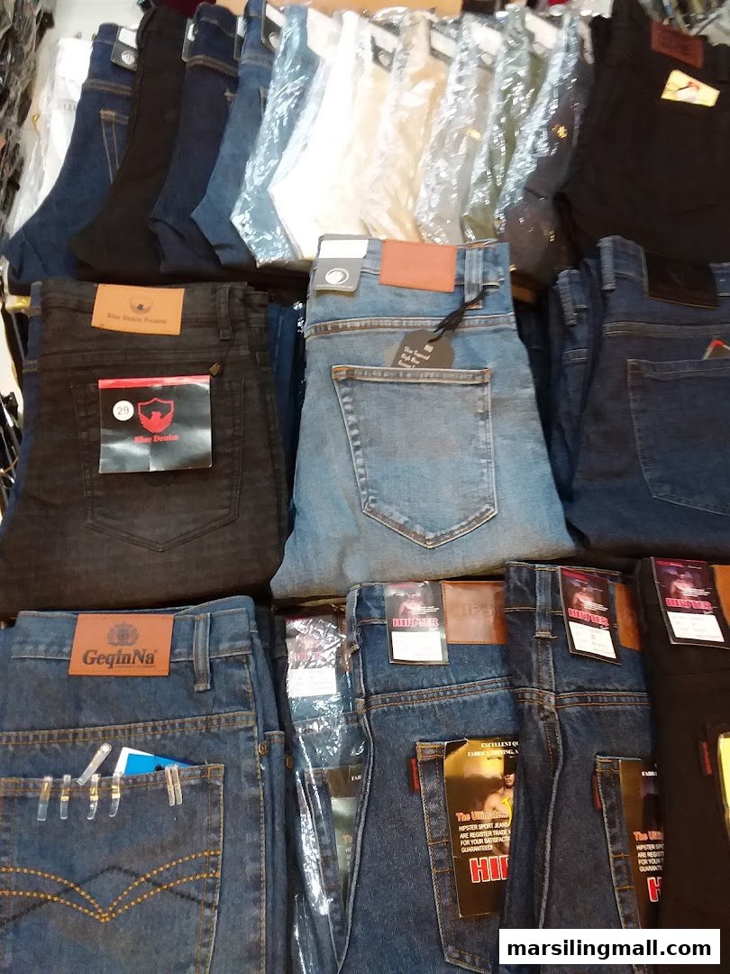 A close-up view of various denim jeans neatly folded and displayed in a fashion shop.