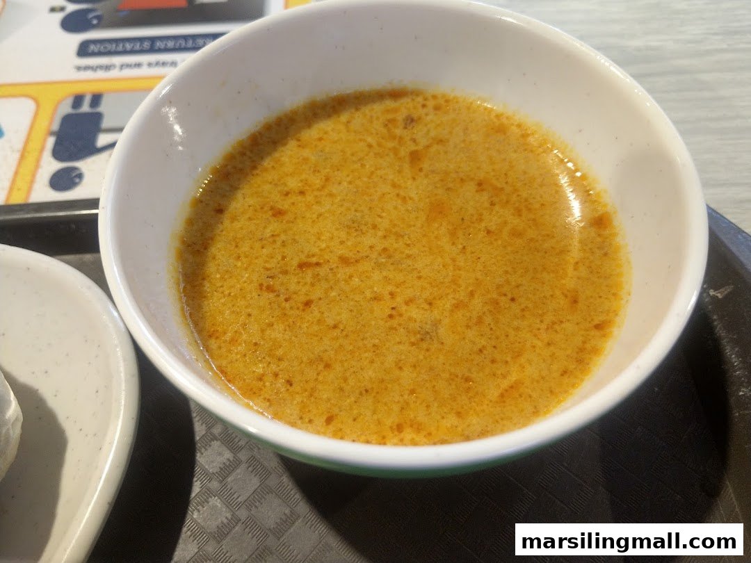 A close-up of a bowl of rich, golden curry from Hai Nan Hometown Curry.