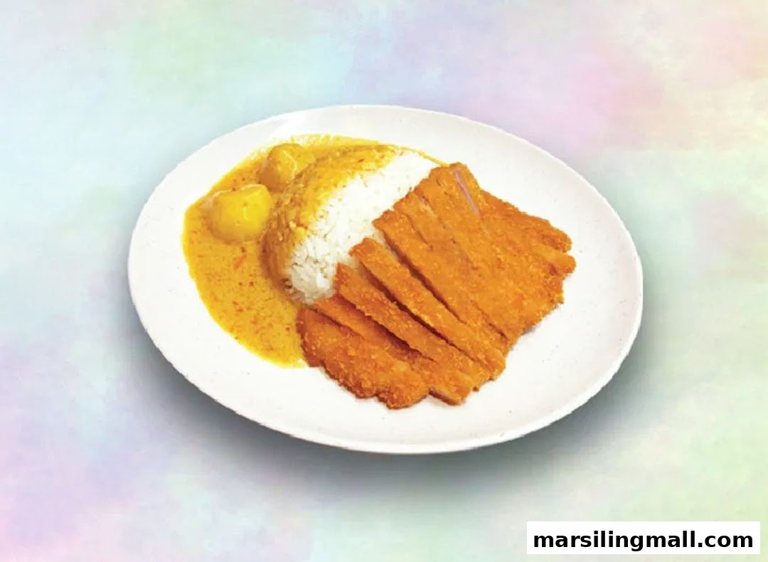 A plate of golden fried cutlet with rice and rich curry sauce, featuring potatoes.