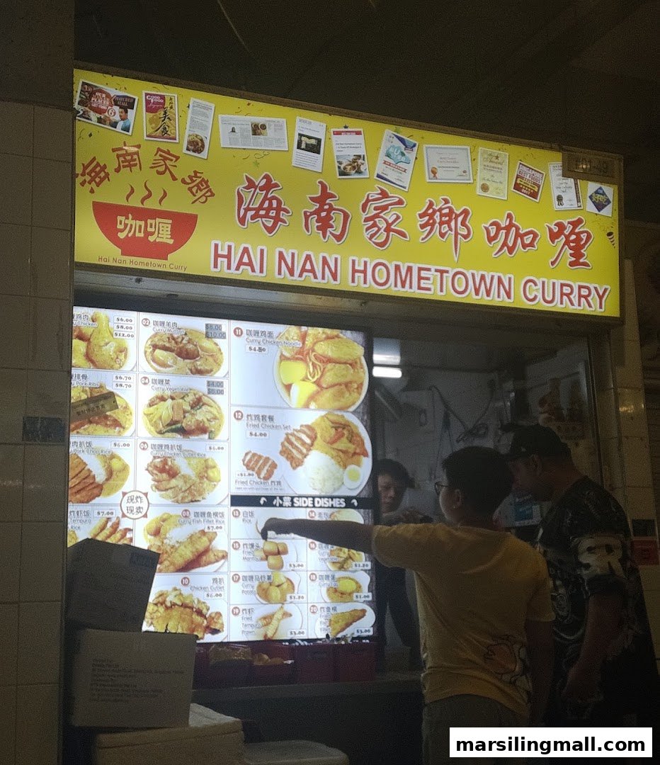 A brightly lit digital menu board displaying various curry and fried dishes at Hai Nan Hometown Curry.
