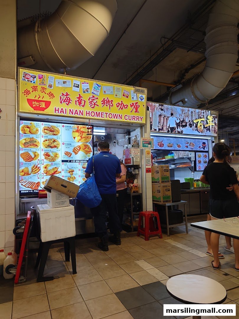 A bustling view of Hai Nan Hometown Curry's stall front, showcasing its vibrant digital menu.