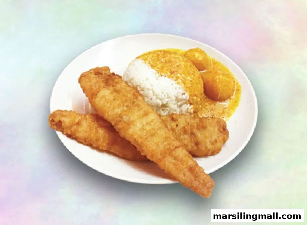 A plate of golden fried fish fillets served with white rice and rich yellow curry.