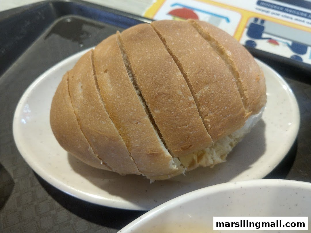 A close-up of a freshly sliced bread roll served on a white plate.