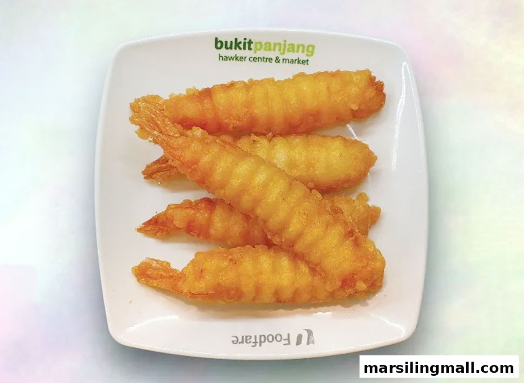 A plate of golden-brown fried prawns, likely tempura or battered, served on a white dish.
