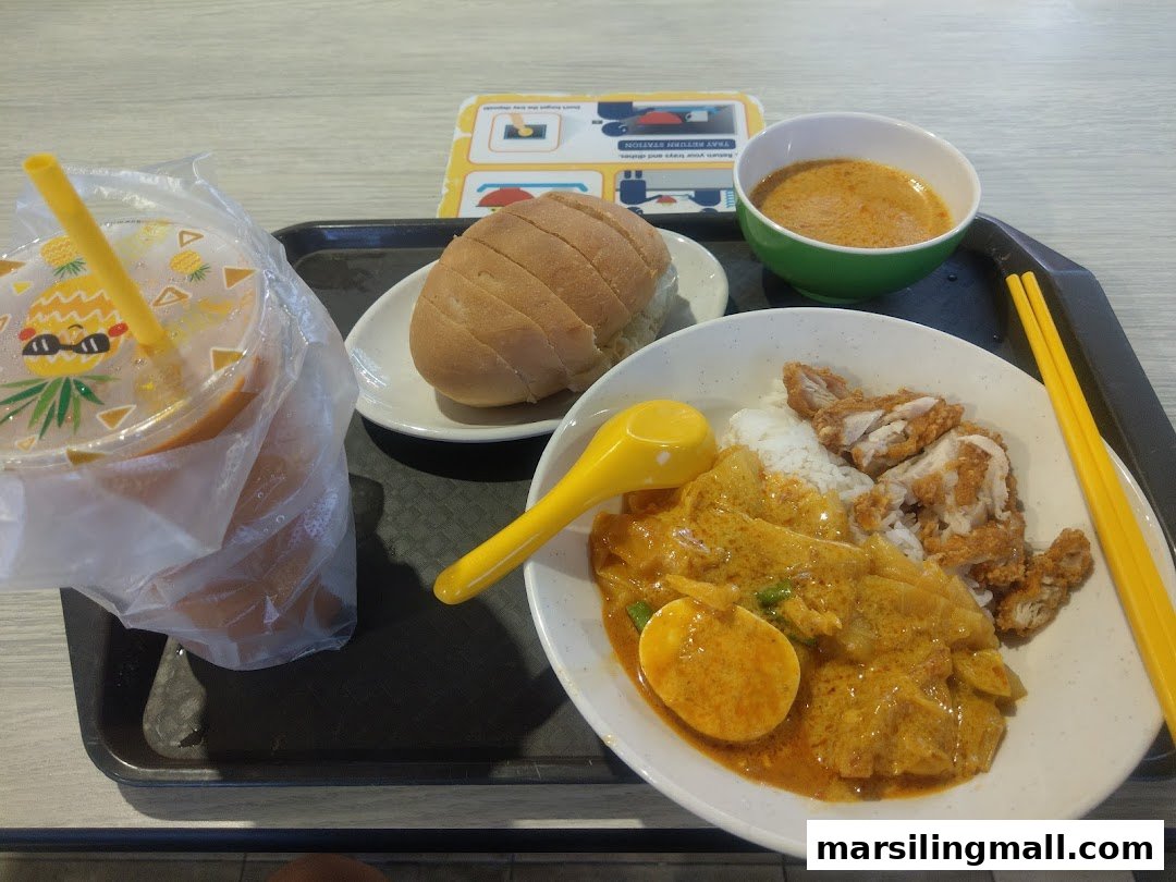 A delicious meal featuring curry chicken with rice, fried chicken, a side of bread, and a refreshing drink.