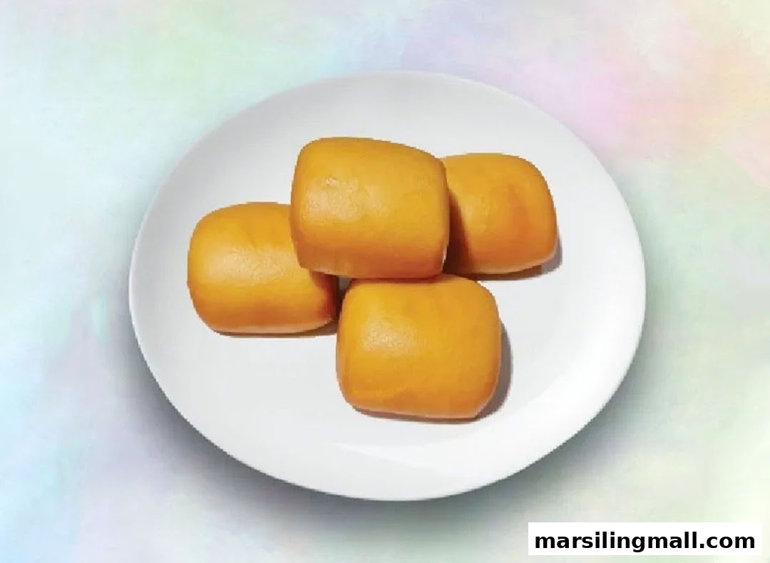 Four golden-brown, square-shaped buns are neatly arranged on a white plate.