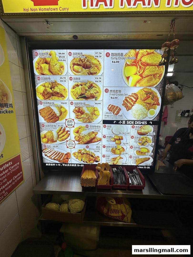 A brightly lit menu board for 'Hai Nan Hometown Curry' displaying various curry dishes, rice sets, and side dishes with prices.