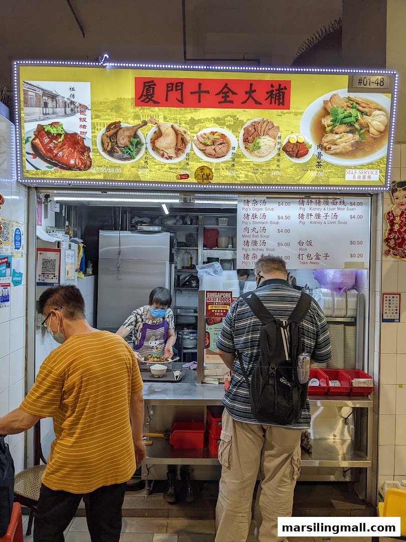 A bustling food stall with customers and staff, featuring a prominent menu board with traditional Chinese dishes.