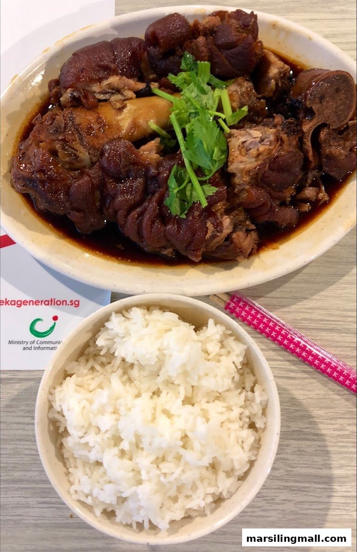 A hearty plate of braised pig trotters with fresh cilantro, served alongside a bowl of white rice.