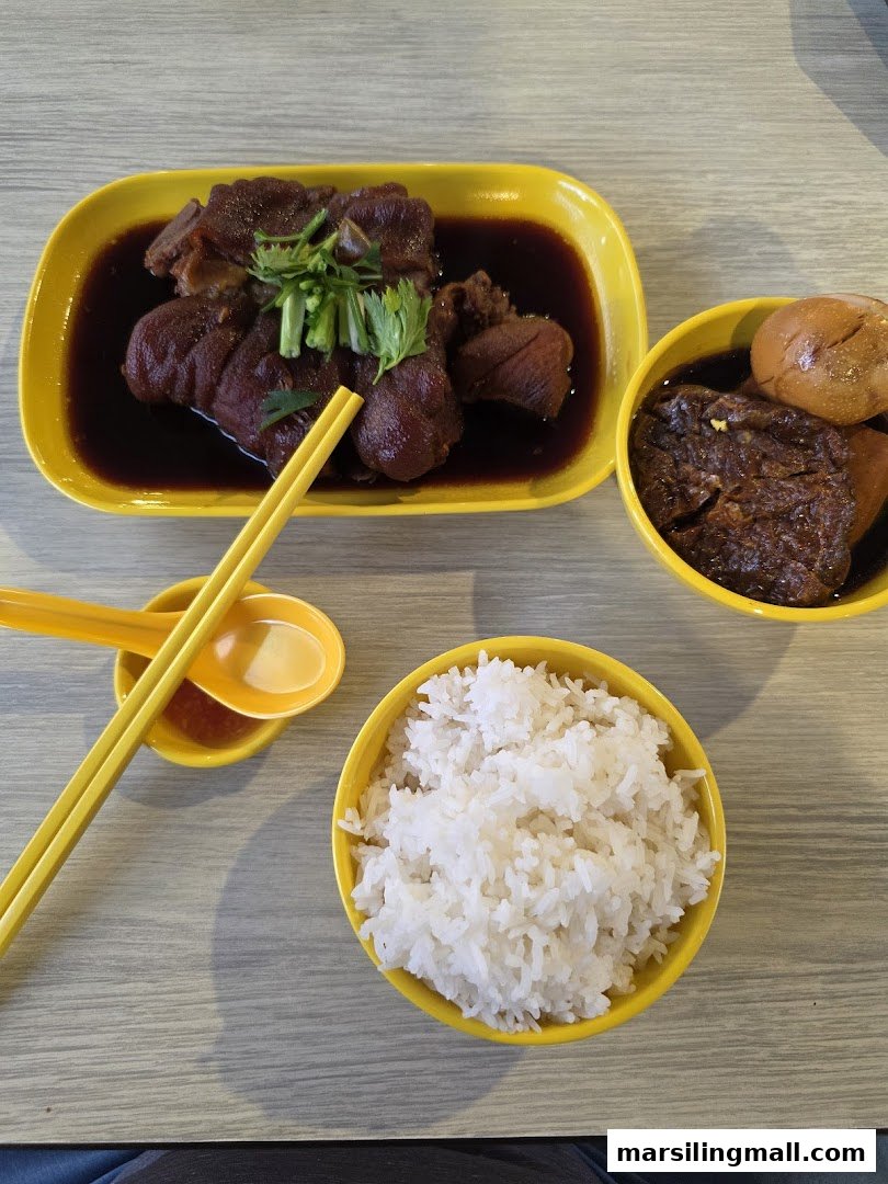 A delicious meal featuring braised pig trotters, rice, and other savory dishes in yellow bowls.